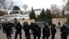 Policia çeke ruan zonën ndërsa protestuesit mblidhen përpara Ambasadës Ruse në Pragë. 