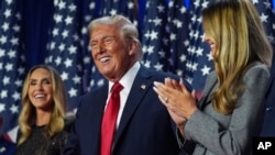 Donald Trump republikánus elnökjelölt győzelmi beszéde után, mellette felesége, Melania Trump (j) és menye, Lara Trump a floridai Palm Beach County Convention Centerben 2024. november 6-án