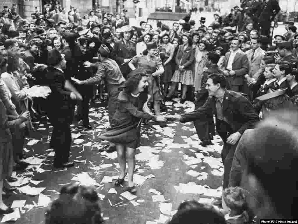 Gra britanike kërcejnë me ushtarë amerikanë në Londër më 8 maj 1945 – dita kur Gjermania naziste kapitulloi.