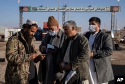 Talibanski borac provjerava dokumente na afganistansko-iranskom graničnom prijelazu Islam Qala, 24. novembra 2021.