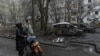 Banorë lokalë kalojnë pranë automjeteve të djegura nga sulmet ruse me dronë. Dnipro, 9 prill 2025.
