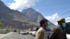 Men wear protective face masks as a preventive measure against coronavirus disease (COVID-19) outbreak as they stand by a queue of vehicles at a check post while entering Gilgit in northern Pakistan on March 22.