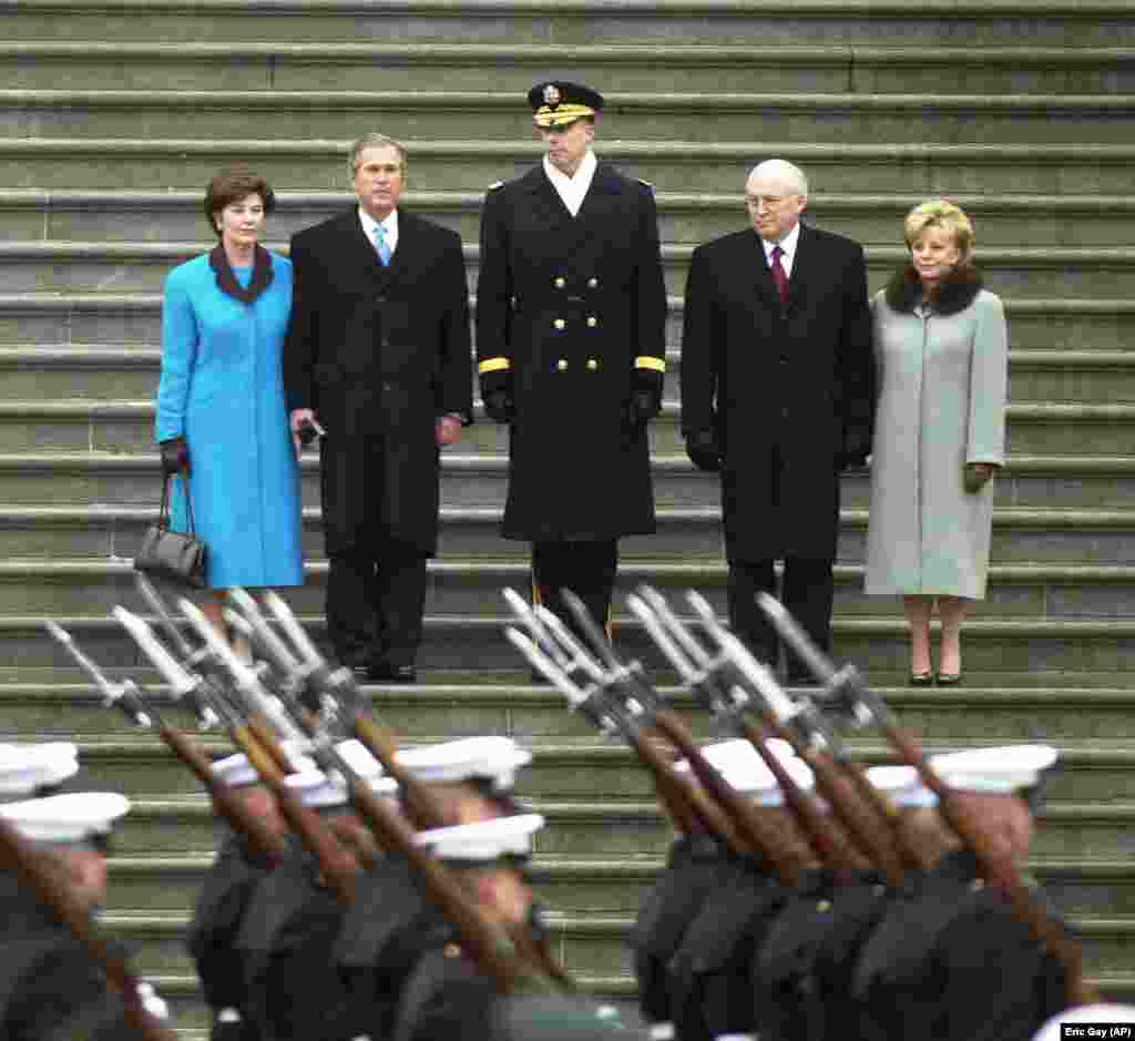 Presidenti George W. Bush me bashkëshorten Laura (në të majtë) në shkallët e Kapitolit me zëvendëspresidentin Dick Cheney dhe bashkëshorten e tij, Lynne (djathtas), pas inaugurimit të tyre më 20 janar 2001. Bush shërbeu gjatë dy mandateve si president. &nbsp;