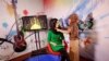 Khatira Ahmadi (djathtas), 20-vjeçare, producente e kanalit Zan TV, duke rregulluar shaminë e një prezantuese, para transmetimit. (Kabul, 8 maj 2017)
