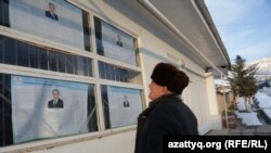 Житель Ташкентской области читает на плакатах информацию о кандидатах в президенты Узбекистана.