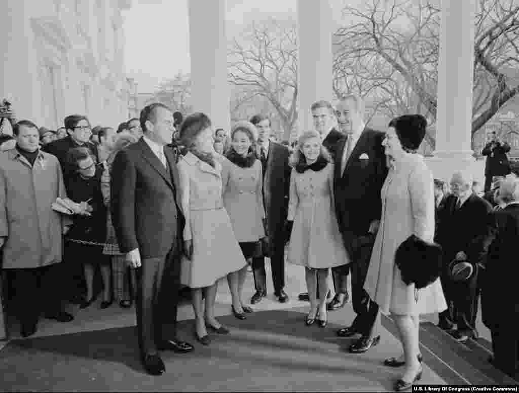 Noul președinte Richard Nixon (stânga) și familia sa salută familia președintelui Johnson pe 20 ianuarie 1969. Nixon a fost ales președinte de două ori, dar a demisionat în urma scandalului Watergate, în timpul&nbsp;celui de-al doilea mandat.
