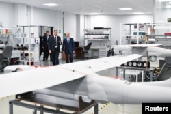 Președintele rus Vladimir Putin (centru) vizitează o unitate de producție de drone din Sankt Petersburg. (fotografie de arhivă).