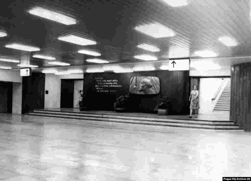 Një pllakë për Vladimir Leninin brenda një stacioni të metrosë që quhej Leninova. Fotografia u shkrep në vitin 1978. Shkrimi pranë pllakës është nga një poezi propagandistike: &ldquo;Askush nuk është më i gjallë se Lenini në këtë botë. Fuqia jonë, mençuria jonë janë armët më të sigurta&rdquo;. Kjo pllakë thuhet se fshihet ende mes rrjetave dhe kabllove në stacionin që tani quhet Dejvicka. &nbsp; &nbsp; 