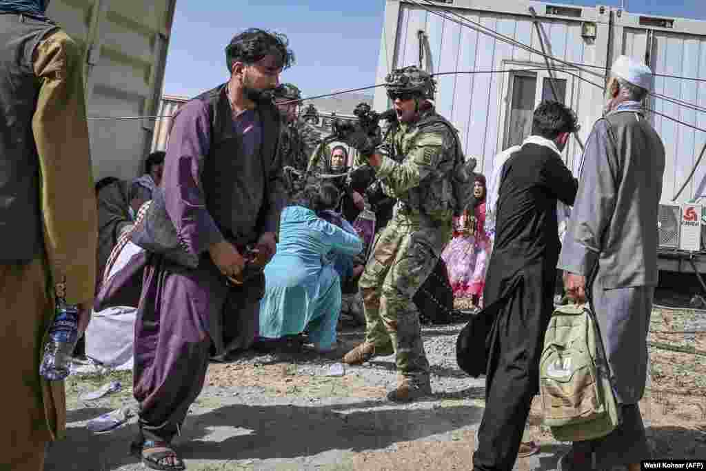 A U.S. soldier points his gun toward an Afghan at the airport in Kabul. 