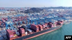 Кранови растоваруваат контејнери од брод на пристаништето во Кингдао во провинцијата Шандонг во источна Кина / 2 април 2025