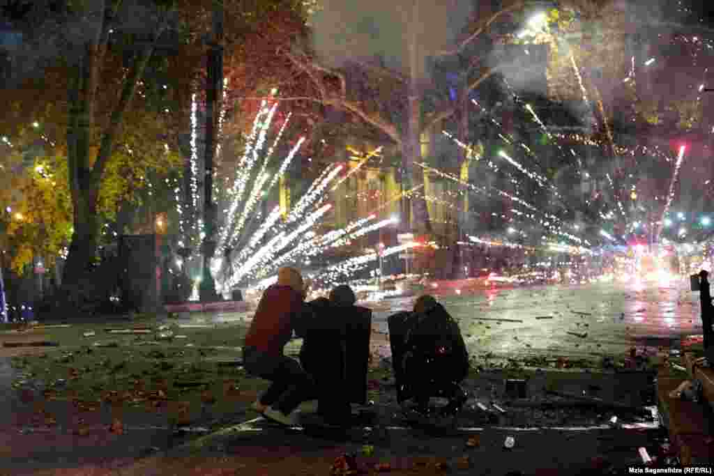Protestatarii trag focuri de artificii spre poliție pe 4 decembrie, în timpul protestelor de pe bulevardul Rustaveli din Tbilisi. Tulburările actuale legate de decizia guvernului georgian de a întrerupe negocierile de aderare la UE s-au concentrat în jurul acestei artere din Tbilisi. Aceasta este cea mai recentă dintr-o lungă listă de tulburări politice cărora celebra stradă le-a fost martor.