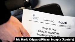 Një person në Danimark mban në duar një pasaport për COVID-19 që është lëshuar nga autoritetet daneze.
