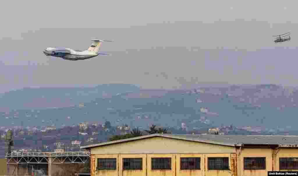 Un avion rusesc de transport, decolând de la baza Hmeimim pe 15 decembrie, în timp ce un elicopter de luptă îl supraveghează îndeaproape. Umit Bektas spune că baza forfotește de avioane, dar străzile din jurul ei sunt &bdquo;foarte liniștite&rdquo;: &bdquo;Se văd cărucioare, un scaun cu rotile abandonat, o mulțime de lucruri împrăștiate pe drum. Ai senzația că ceva s-a întâmplat, când de bază s-au apropiat rebelii&rdquo;.