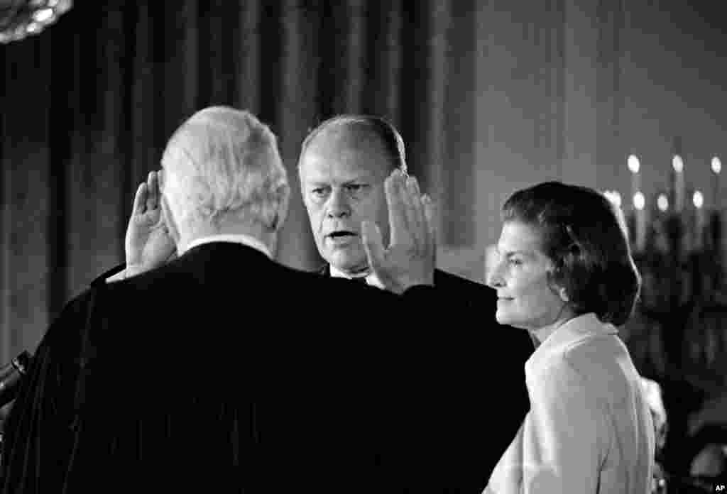 Gerald R. Ford duke u betuar si presidenti i 38-të i Shteteve të Bashkuara brenda Shtëpisë së Bardhë, ndërsa bahskëshortja e tij, Betty, shikon. Inaugurimi u bë më 9 gusht 1974, ditën e dorëheqjes së presidentit Nixon.
