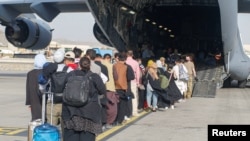Евакуирани се собираат пред да се качат на авионот C-17 Globemaster III за време на евакуација на меѓународниот аеродром Хамид Карзаи, Авганистан. 18 август 2021 година.