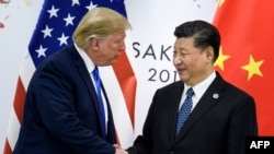 Në këtë foto të realizuar më 28 qershor 2019, Presidenti i Kinës, Xi Jinping, shtrëngon duart me Presidentin amerikan, Donald Trump, gjatë një takimi dypalësh në kuadër të Samitit të G20 në Osaka.