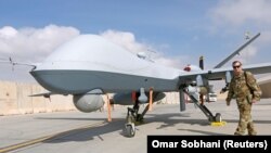 یک افسر نیروی هوایی آمریكا در مقابل یك طیارۀ بدون سرنشین در میدان هوایی قندهار،۲۳ جنوری ۲۰۱۸ 