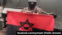 Ukrán katona egy Dávid-csillagos ukrán nacionalista zászlóval. A színek a világháborús Ukrán Felkelő Hadsereg zászlaját idézik.