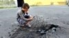 Хлопчик фотографує на телефон воронку від вибуху, Донецьк, 22 липня 2014 року