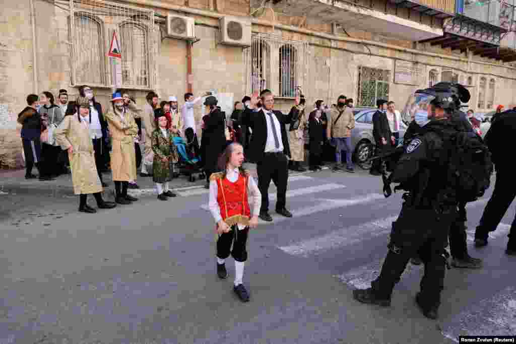 Jeruzsálemben rendőrök felügyelik a Purim ünneplését az utcán.