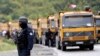 Një pjesëtar i policisë speciale të Kosovës qëndron pranë kamionëve në një rrugë pranë pikës kufitare veriore të Kosovës në Jarinje, 20 shtator 2021. 