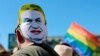 Egy résztvevő Orbán Viktor miniszterelnököt ábrázoló maszkot visel a fején a Budapest Pride Felvonuláson, 2025. június 28-án