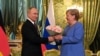 Vladimir Putin îi oferă flori Angelei Merkel în timpul întâlnirii de la Kremlin, 20 august 2021