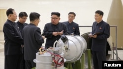 Kim Džong UN pored uređaja koji su severnokorejski državni mediji označili kao novu hidrogensku bombu