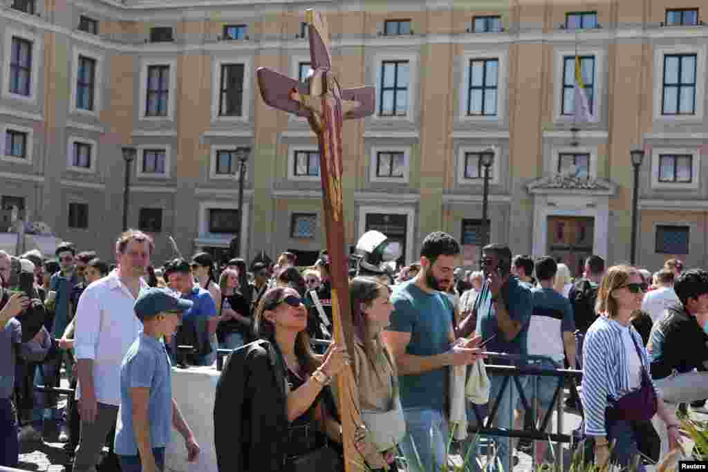 Një grua mban një kryq në Sheshin e Shën Pjetrit në Vatikan, pas vdekjes së Papa Françeskut, në Romë, Itali.