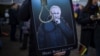 O pancartă care îl înfățișează pe președintele Rusiei, Vladimir Putin, afișată de un participant la protestul împotriva invaziei rusești în Ucraina, în fața Ambasadei ruse din Vilnius, pe 1 martie 2022.