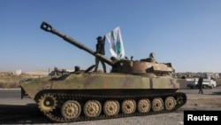 Мъж развява знаме на Хаят Тахрир аш Шам върху военна машина в Саракеб.