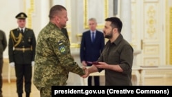 Președintele ucrainean Volodimir Zelenski (dreapta) îi înmânează comandantului suprem al forțelor armate, Valeri Zalujnîi, Crucea Meritul de Luptă, Kiev, mai 2022.