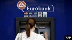Žena podže novac sa bankomata u Atini