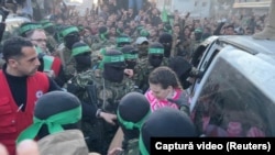Militanți palestinieni Hamas o predau pe Doron Steinbrecher, ostatică israeliano-română, unor membri ai Comitetului Internațional al Crucii Roșii, la 19 ianuarie 2025.