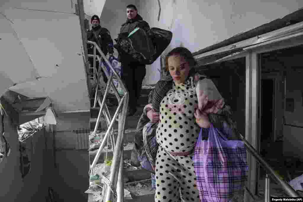 Një grua e lënduar shtatzënë duke zbritur shkallët, në një ndërtesë të shkatërruar të spitalit të lindjes, pas sulmeve ruse, në Mariupol, më 9 mars.