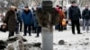 Люди розглядають залишки ракетного снаряду на вулиці Краматорська. 10 лютого 2015 року
