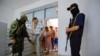 Banorët e Hersonit i nënshtrohen një kontrolli sigurie në një zyrë për të aplikuar për pasaporta ruse, të cilat tani kërkohen në rajonin e kontrolluar nga Rusia për të punuar, vozitur dhe për të marrë ndihmë financiare. 25 korrik 2022.