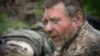 Un soldat ucrainean primește primul ajutor pe un drum în apropiere de Bahmut, la 11 mai.