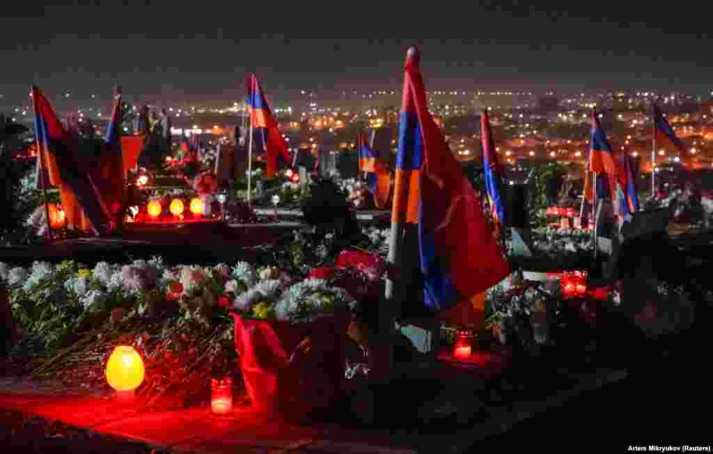 Ерменски знамиња и свеќи ги покриваат воените гробишта Јераблур во Ереван на 18 декември. Фотографијата е направена во пресрет на тридневната национална жалост за оние кои загинаа војувајќи против азербејџанските сили во и околу отцепената област на Азербејџан, Нагорно Карабах.