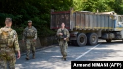 Militari americani din KFOR patrulând lângă un camion sârbesc care bloca șoseaua în apropiere de Zubin Potok, 1 august 2022.