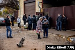 Жители города, которые разыскивают своих родных, стоят в очереди, чтобы предоставить образцы ДНК