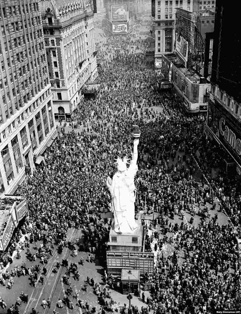 Njerëzit mblidhen rreth Statujës së Lirisë në "Times Square". Një gazetar e përshkruan skenën: “Aty-këtu ndonjë civil pak i dehur, ndonjëherë edhe ndonjë ushtar, u ofron pije të panjohurve. Pijet pranohen me dëshirë, kryesisht nga adoleshentët”.