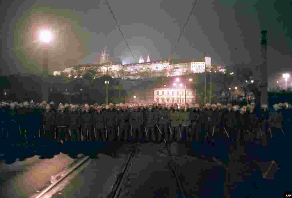 Специалните части блокират близкия мост, за да попречат на демонстрантите да достигнат до Пражкия замък, резиденция на президента на Чехословакия. Снимката е от 19 ноември 1989 г. Протестите стават все по-масови след употребата на сила два дни по-рано.&nbsp;