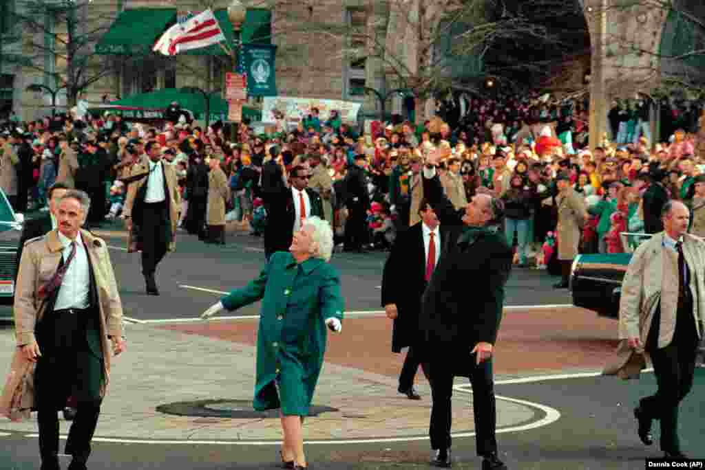 Presidenti George Bush (djathtas), dhe zonja e parë, Barbara Bush, përshëndesin me dorë turmën përgjatë bulevardit Pensilvania. Presidenti i 41-të u betua më 20 janar 1989.