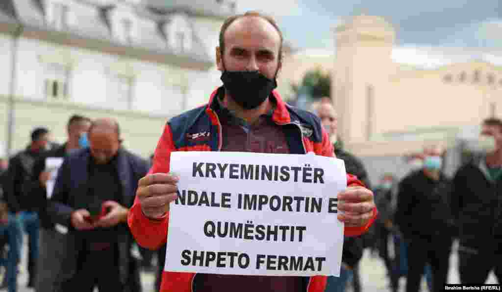 Një protestues mban pankartën me mbishkrimin "Kryeministër, ndale importin e qumështit, shpëto fermerët".