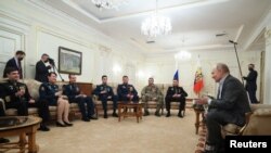 Președintele rus Vladimir Putin întâlnindu-se cu soldați implicați în invazia din Ucraina la reședința sa de lângă Moscova, 1 ianuarie 2024 (Sursă: Kremlin via REUTERS) 