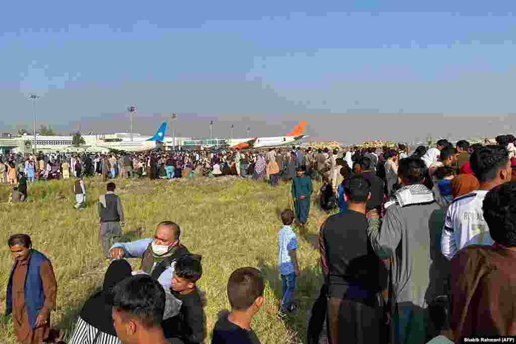 Afghans crowd at the airport as they wait to leave Kabul. 