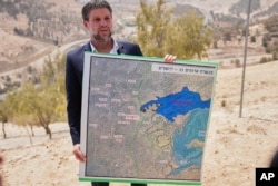 Ministrul israelian de finanțe Bezalel Smotrich prezentând un plan de compromitere a proiectului statului palestinian prin construcția de așezări evreiești în Cis-Iordania, la 14 august 2025.