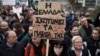 „Grecia își omoară copiii”, susține pe o pancartă o fată care participă la protestul de vineri, în fața Parlamentului elen. 