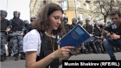 Протестираща чете конституцията на Русия по време на протеста, 27 юли 2019 г.